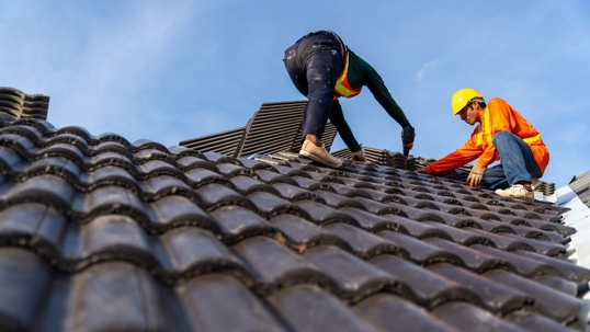 Roofers working on a ceramic tile roof