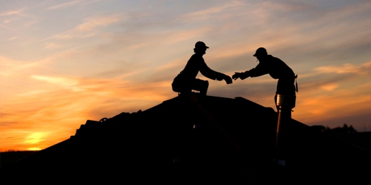 roofing employees working on a house's roof