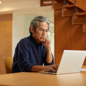 Older man using laptop in his home