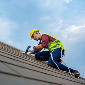 Roofer attaching shingles to roof
