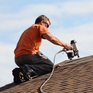 Roofer attaching shingles to roof